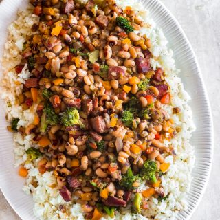 Traditional Hoppin John is thought to bring luck and prosperity. It’s a staple New Year’s day dinner in the south, especially in South Carolina. Classic Hoppin John is made with ham hocks or bacon and cooked in one pot. My quick version uses, smoked sausages and more vegetables like healthy broccoli, frozen black-eyed peas and for kick, a couple pinches of crushed red peppers. This is an easy hearty dish that’s ready in 30 minutes or less.