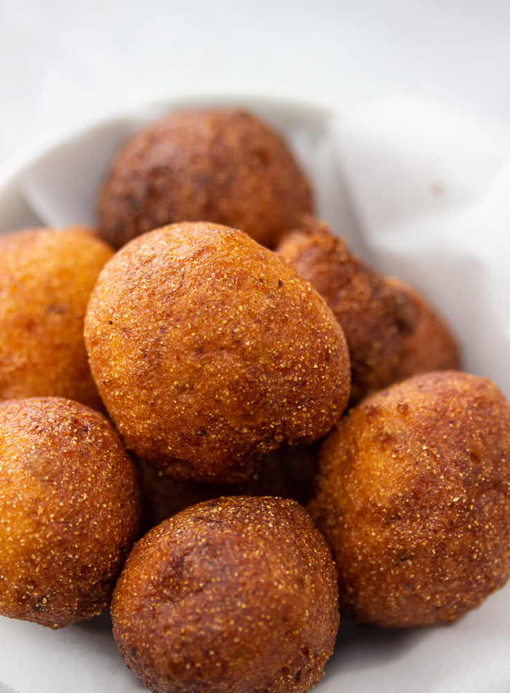 a bowl of golden brown hush puppies