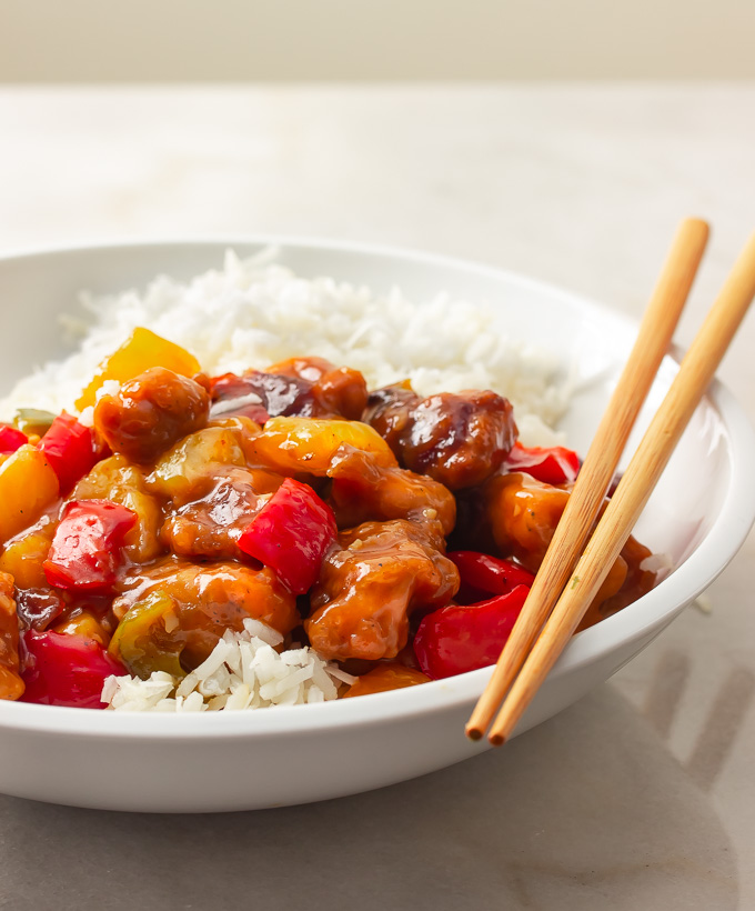 A bowl of sweet and sour chicken over rice