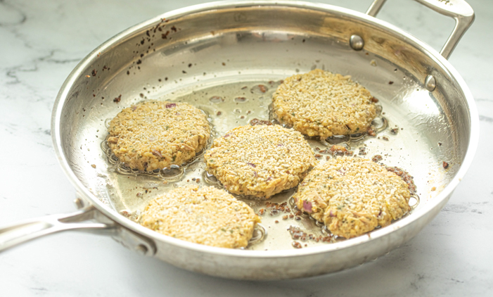 Crispy tuna cakes with breadcrumbs, lemon garlic and herbs frying in a skillet