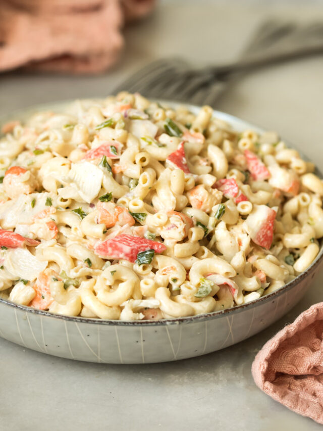 A bowl of the best creamy seafood macaroni salad with fresh parsley, shrimp, crab, and elbow macaroni