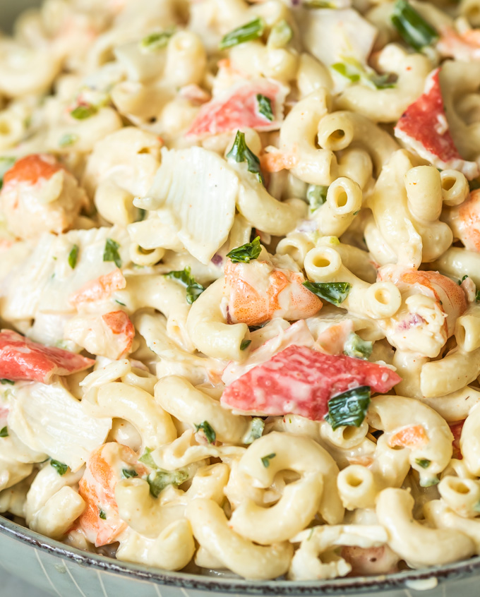 A bowl of the best creamy seafood macaroni salad with fresh parsley, shrimp, crab, and elbow macaroni