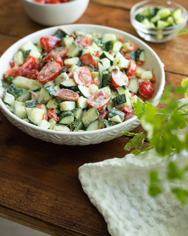 Tomato cucumber salad in a bowl with creamy dill dressing