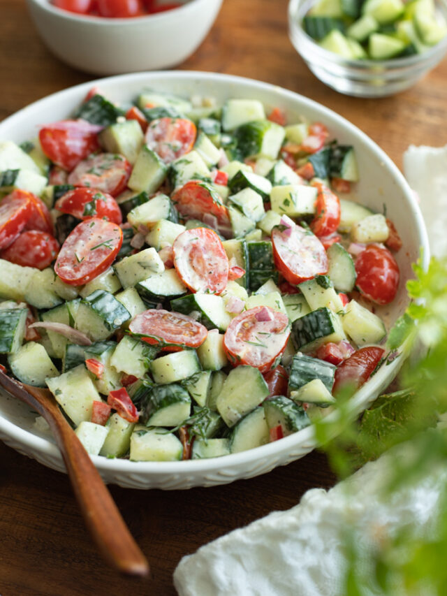 Tomato cucumber salad in a bowl with creamy dill dressing