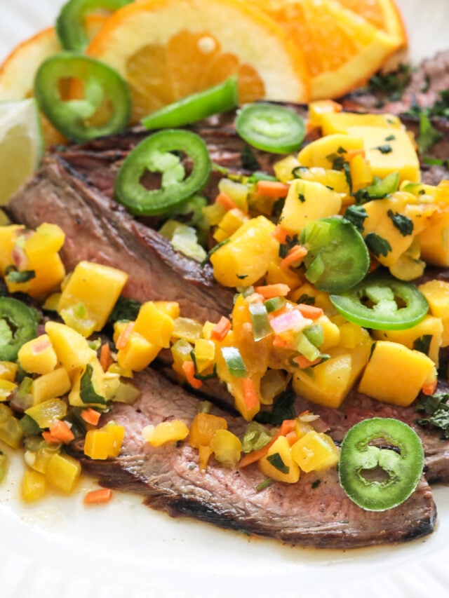 Jerk steak with mango salsa on a white plate with a bottle of mazola heart healthy corn oil behind it