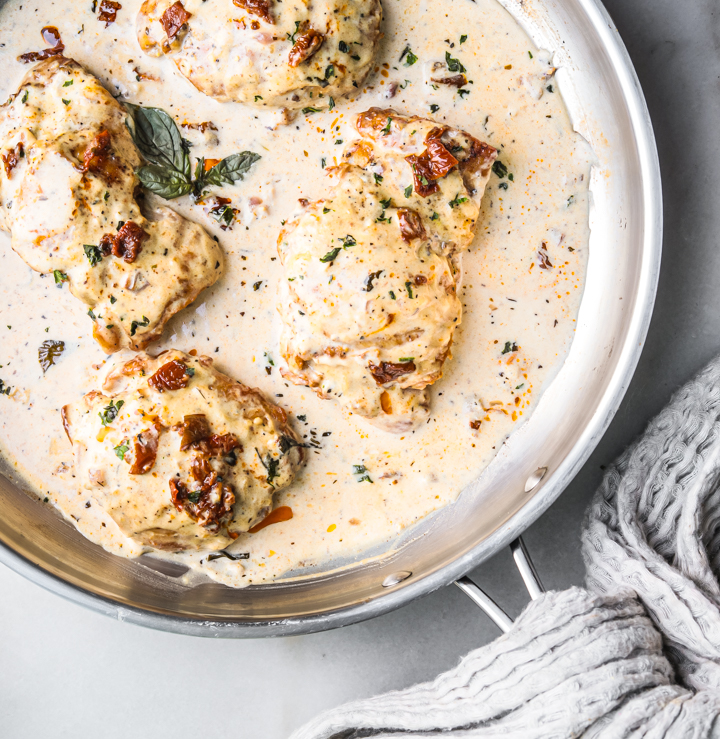 A picture of creamy chicken in basil cream sauce in a pan.