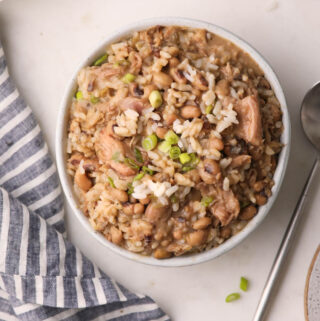 A photo of Hoppin' John with rice and smoked turkey in a white bowl