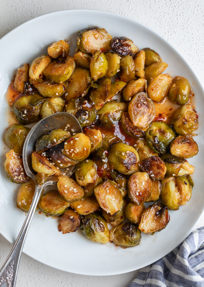 A bowl of roasted brussel sprouts aA bowl of roasted brussel sprouts and sweet chili glaze A bowl of roasted brussel sprouts and sweet chili glaze and sweet chili glaze