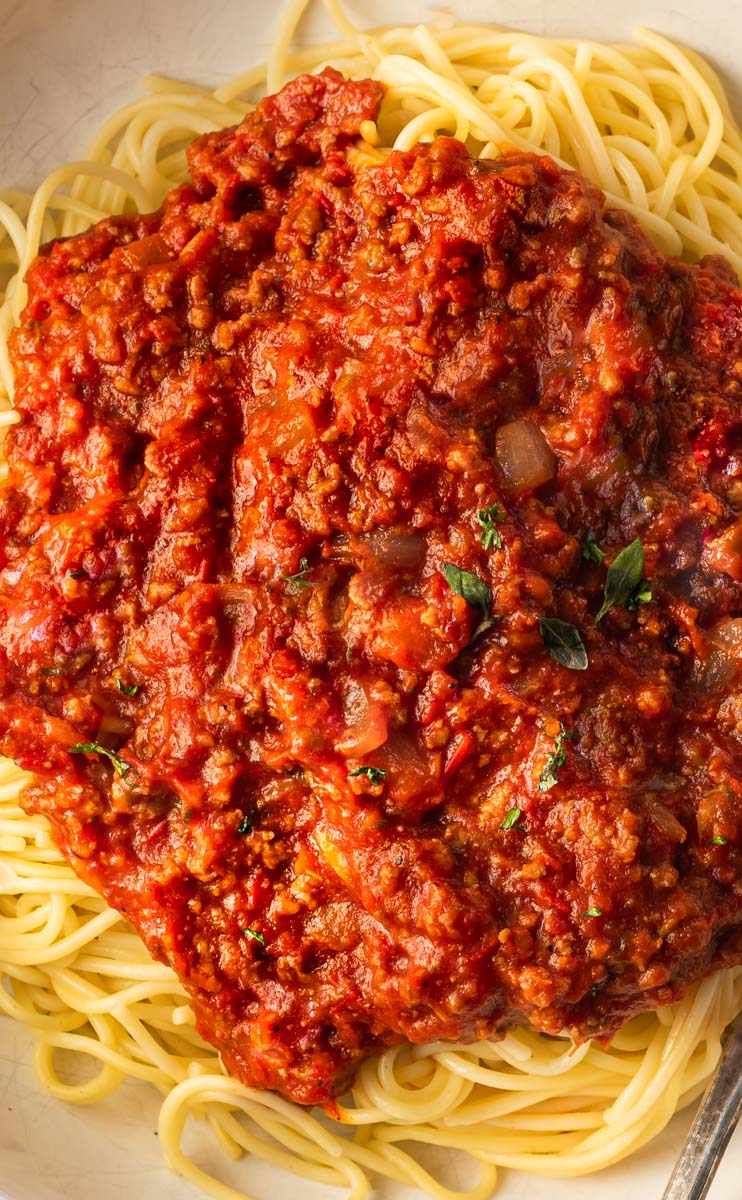 A picture of spaghetti sauce with spaghetti on a plate. 