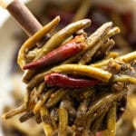 A closeup picture of a spoonful of green beans and peppers